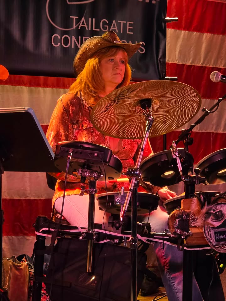 Drummer performing in front of American flag backdrop