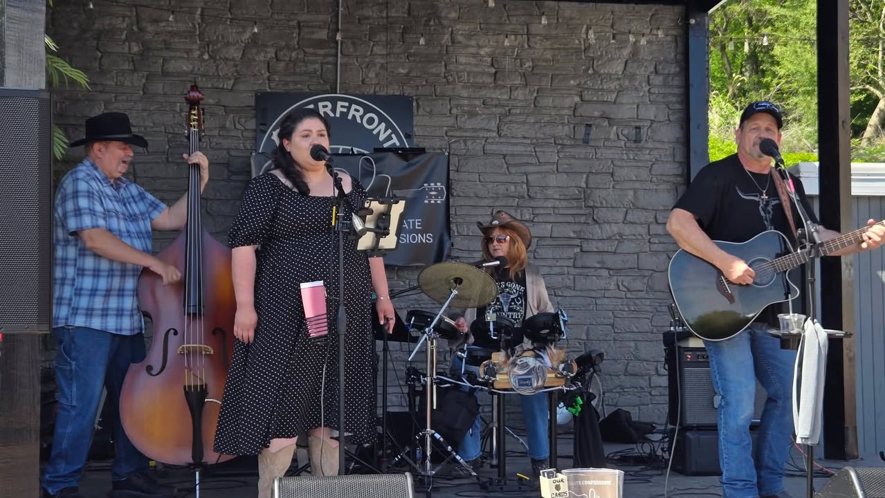 Full band performing on outdoor stage at Riverfront