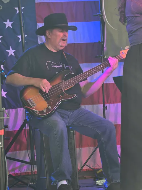 Bassist playing in front of American flag backdrop