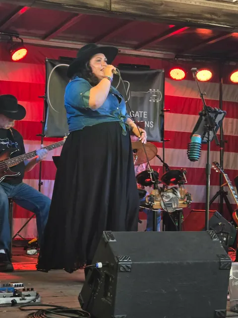Lead vocalist singing on stage with American flag backdrop